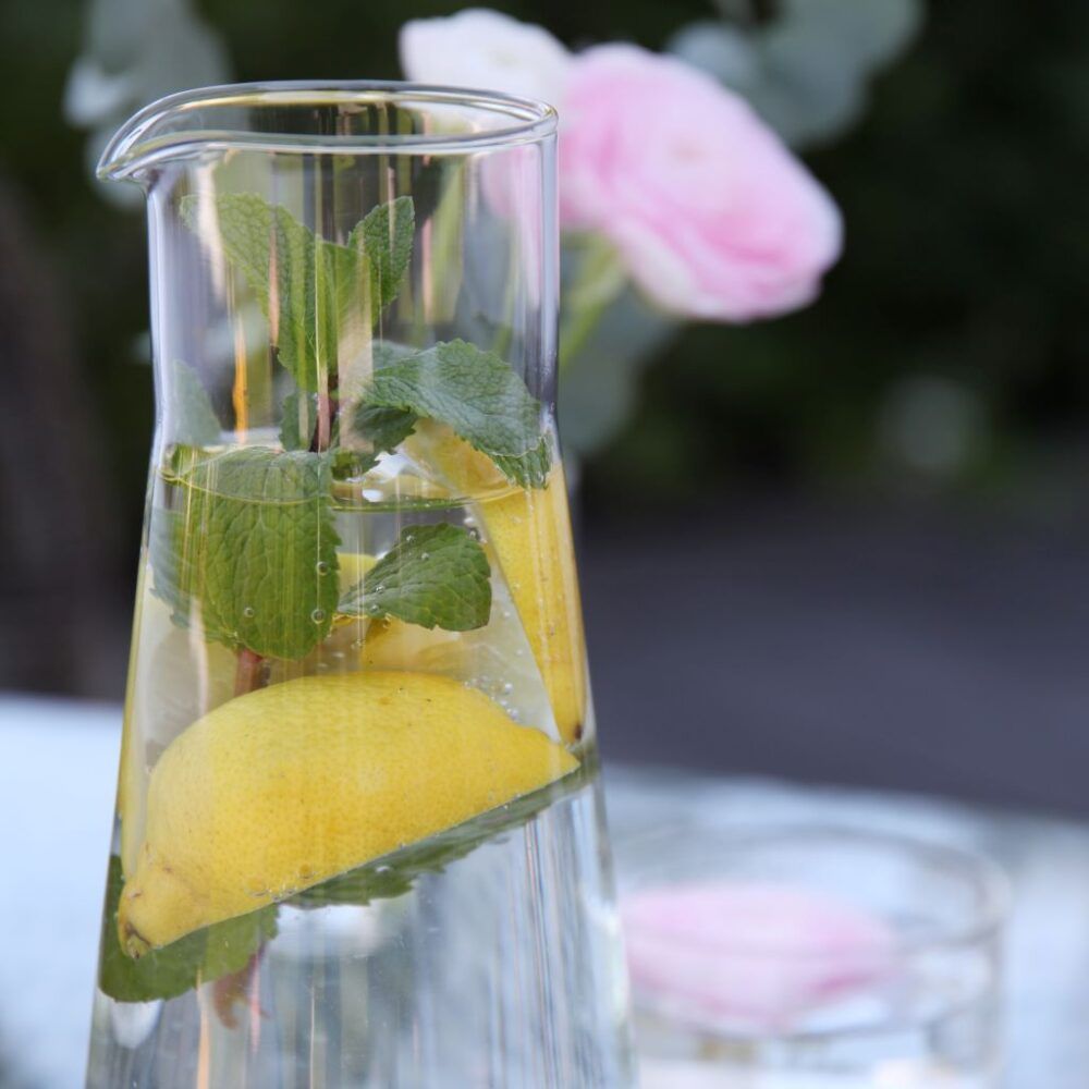 carafe-in-glass-with-lemons-and-flower-orskov